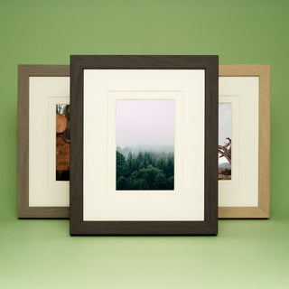 3 different colour wooden frames on a green background