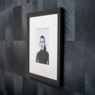 Framed black and white portrait on a textured gray wall