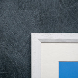 White picture frame on a textured grey wall