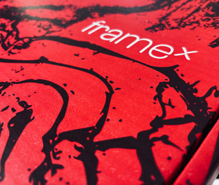 Close-up of a red packaging with black silhouettes and 'framex' branding.