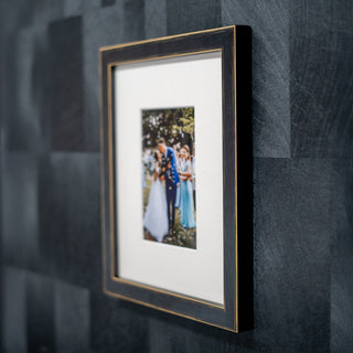 black wood framed photograph of a couple on a textured grey wall