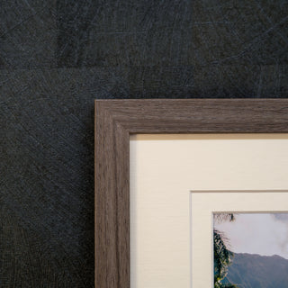 close up of the corner of a Framed photograph on a textured wall 