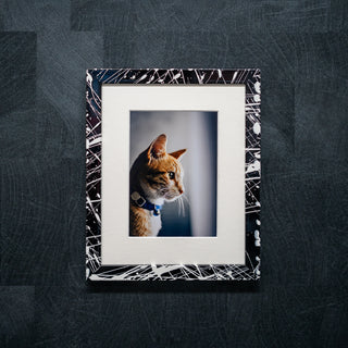 Black and white paint splatter effect frame on a dark grey wall
