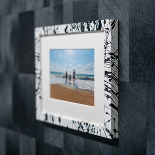 Framed photo of a beach scene with abstract design on frame