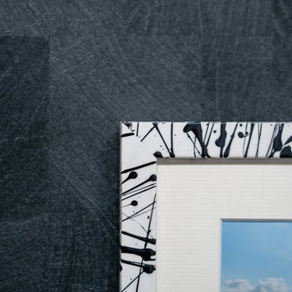 Close-up of a picture frame with abstract black design on a textured gray background