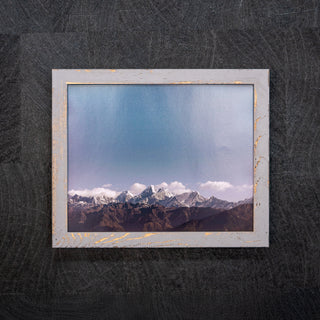 Framed photograph of mountain landscape on a textured black background