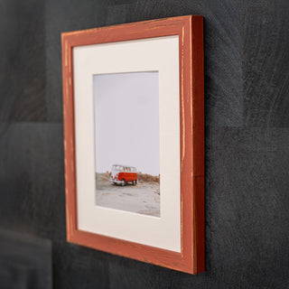 Framed photograph of a red van on a black wall